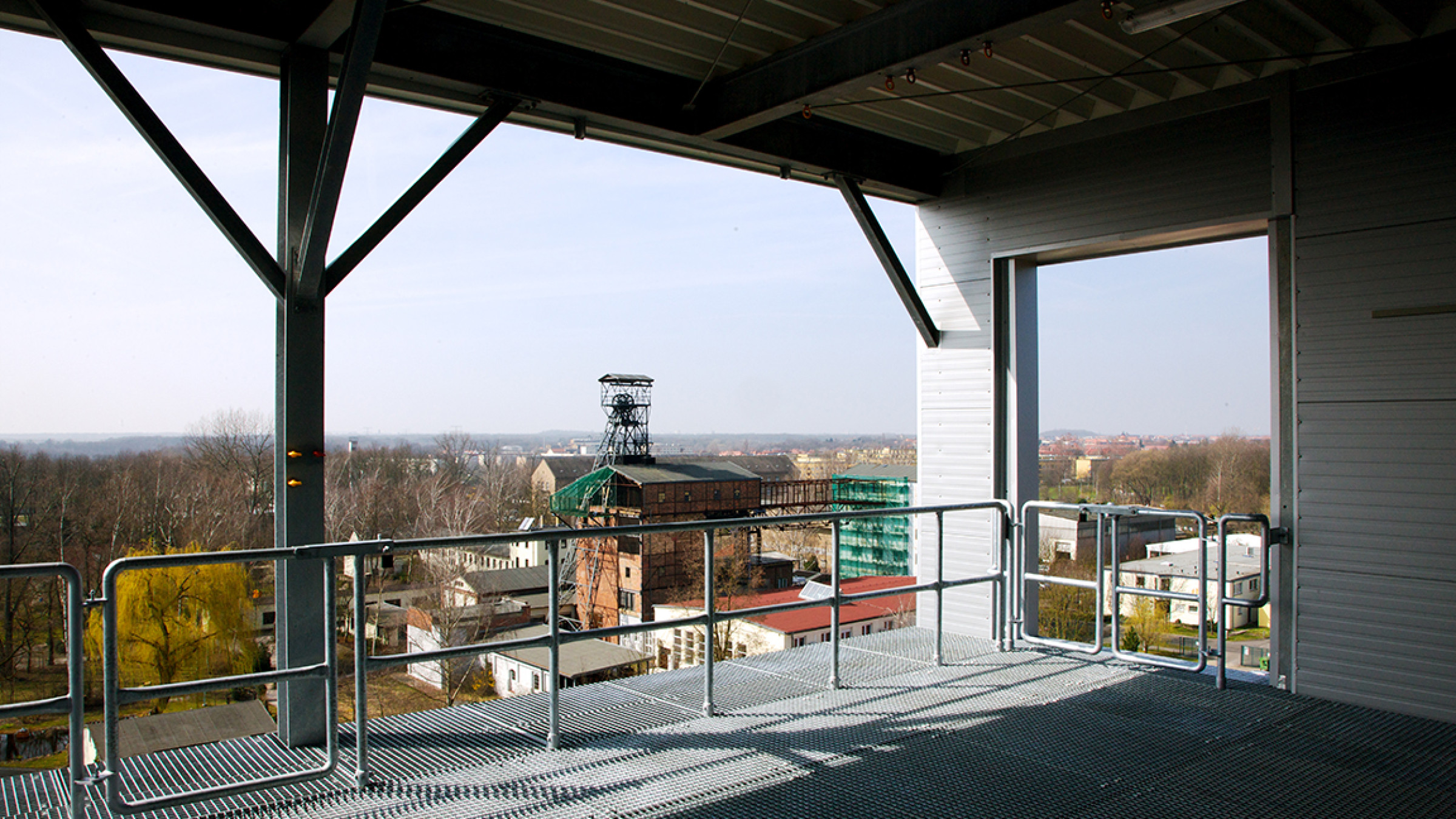 View from a training platform over grating and railings towards the surrounding countryside with a pithead winding tower.